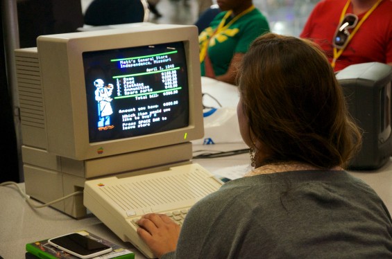 Woman plays The Oregon Trail on a vintage Apple computer